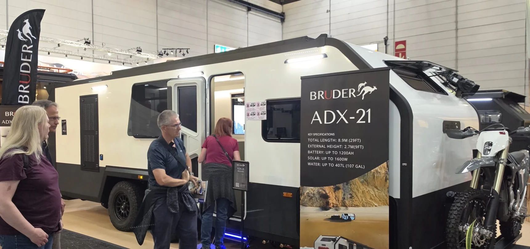 Visitors stepping inside the Bruder ADX-21 on the Bruder stand at Caravan Salon Düsseldorf